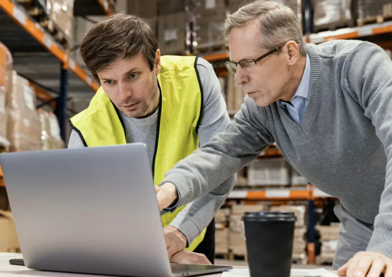 Two men talking about something on laptop